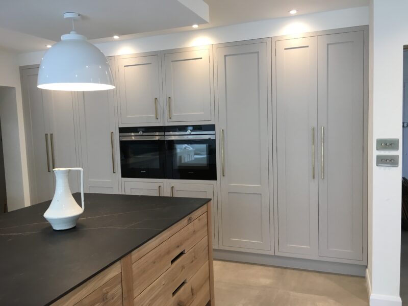 Tall, floor to ceiling cabinets in grey with ovens built in