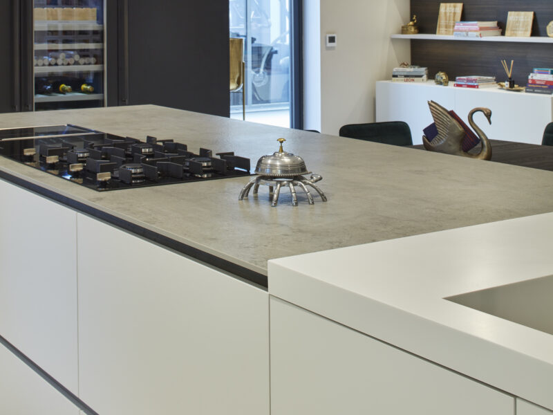 Modern, black and white kitchen with drop lights and hidden storage and a wine fridge