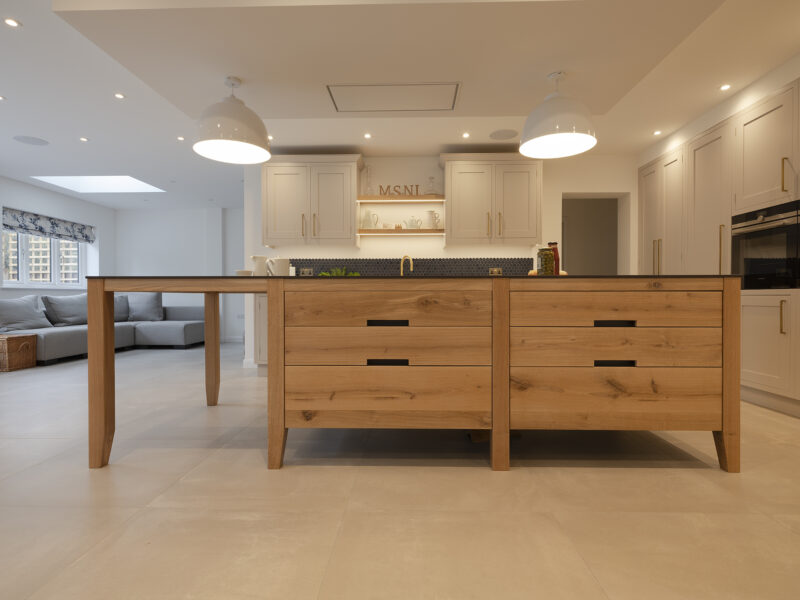 Kitchen hexagonal back splash with gold taps and shaker cupboards with timber island and drawers