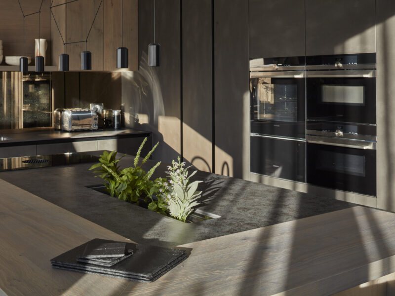 island table in a modern grey kitchen with oven and cupboards in the background
