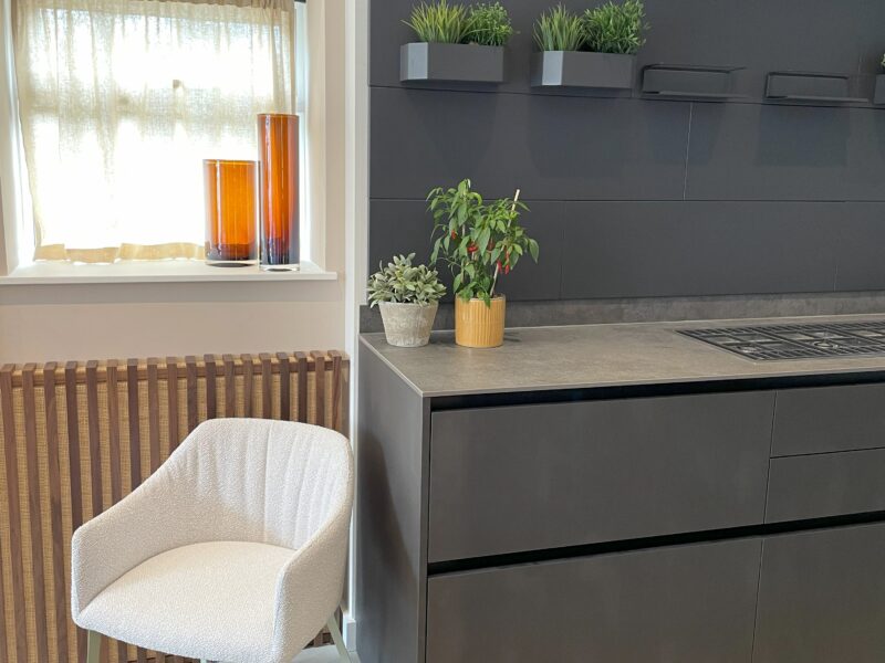 dark cabinetry and a white chair in a modern kitchen
