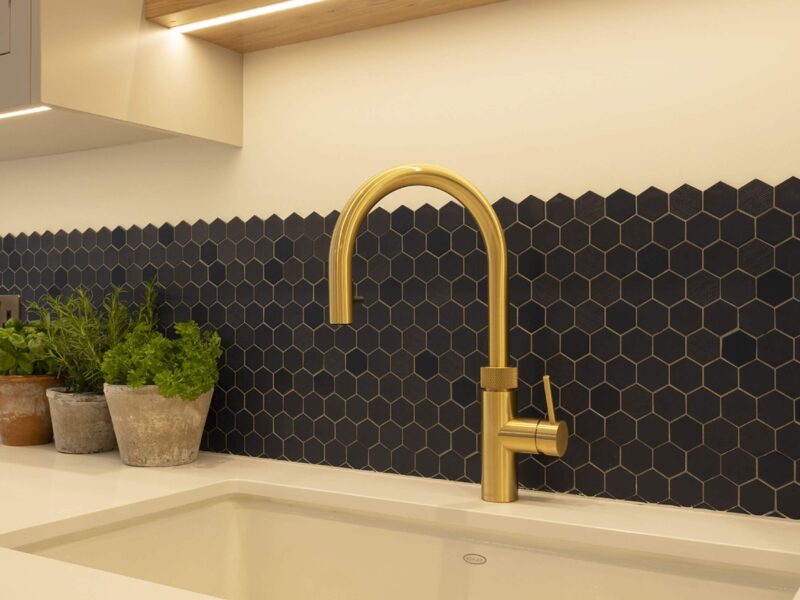 Tiling detail behind a gold tap